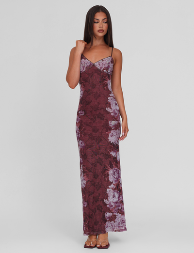 A woman wears the TIGERMIST JULIANNA DRESS—MULTI, FLORAL, ROSE STRIPE, a sleeveless maxi with thin straps—paired with brown heels and stands before a plain light gray background.