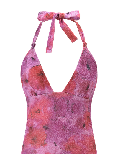 A close-up of the TIGERMIST TALYN MINI DRESS in Pink Sparkle Floral, featuring a halter-neck, textured fabric, playful pink and purple florals, and a neck tie for a chic look.